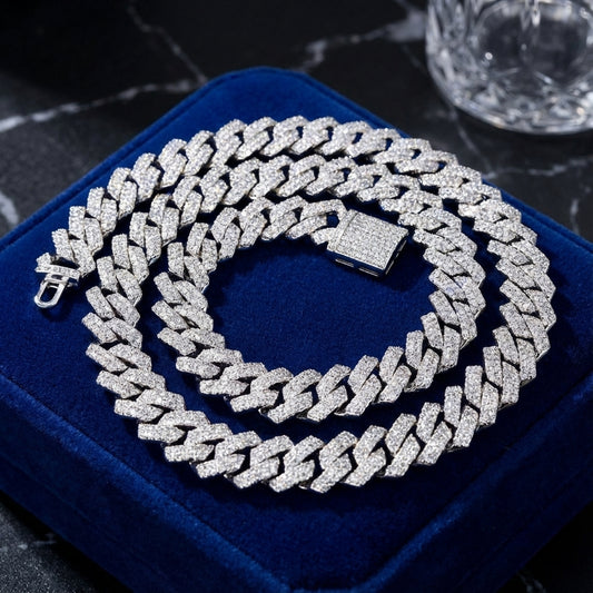 Silver chain necklace on a blue cushion with a dark textured background