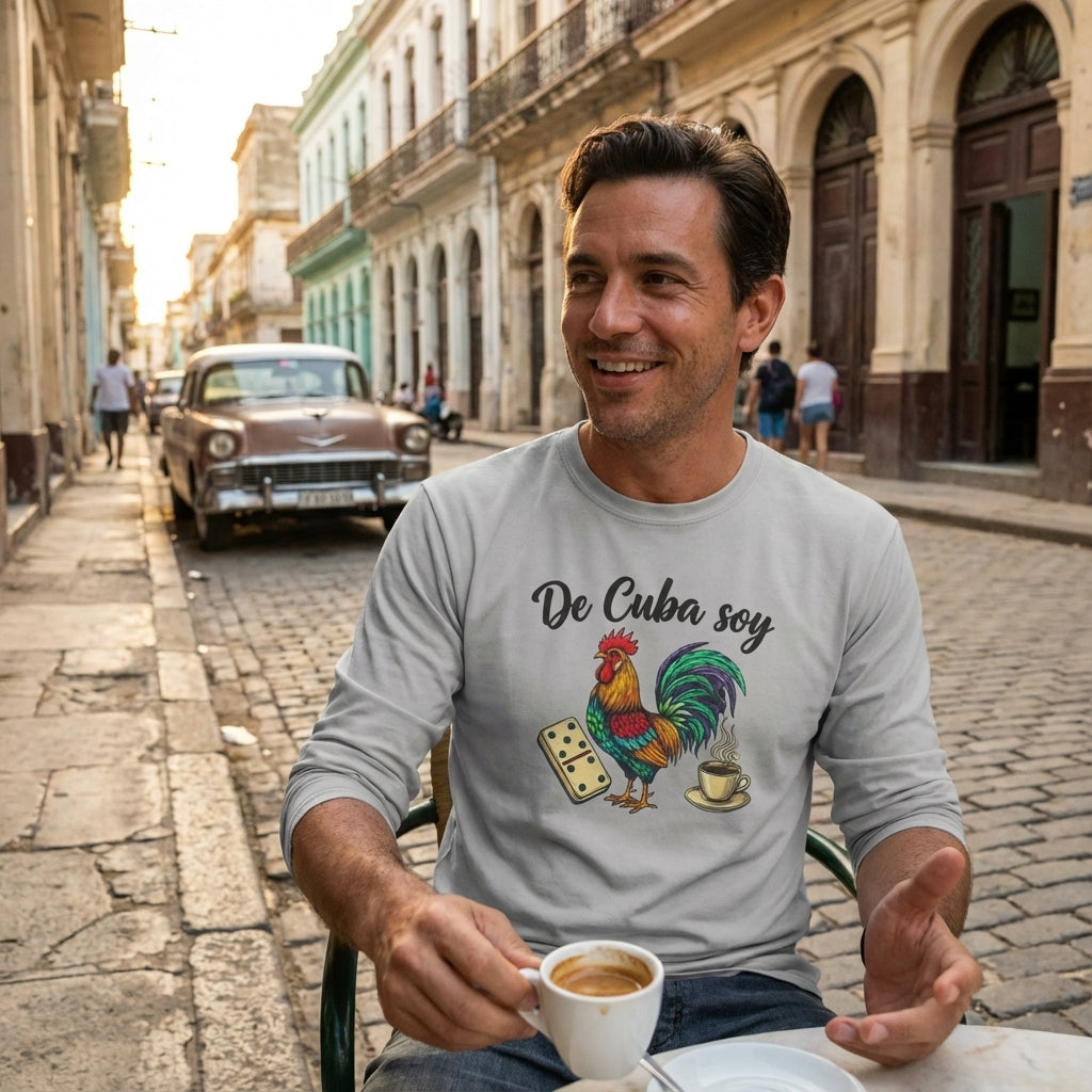 Man sitting on a street in Cuba holding a coffee cup, wearing a shirt with a rooster graphic and text.