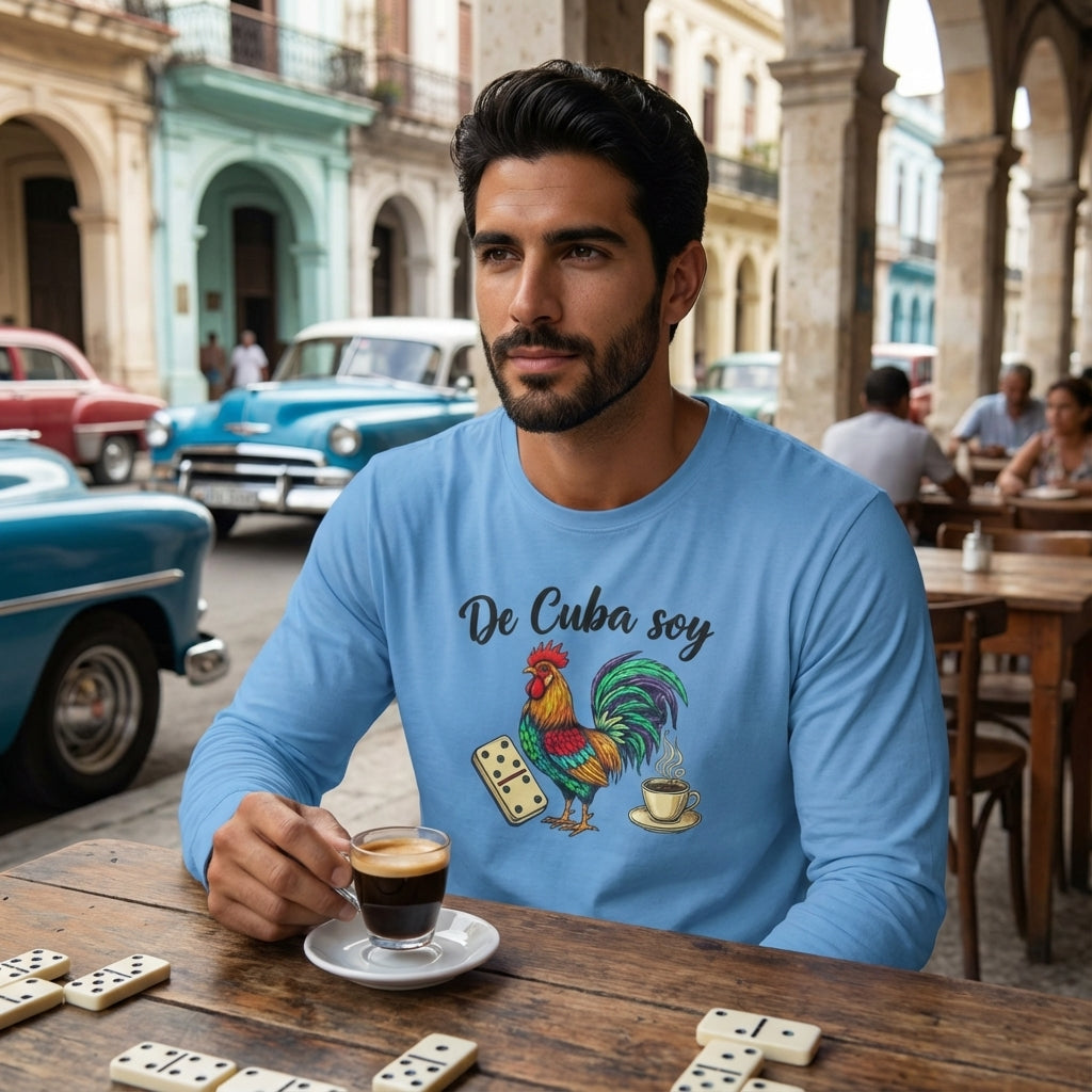 Man sitting at a table with dominoes, holding a coffee cup, wearing a blue shirt with a rooster design in an urban setting.