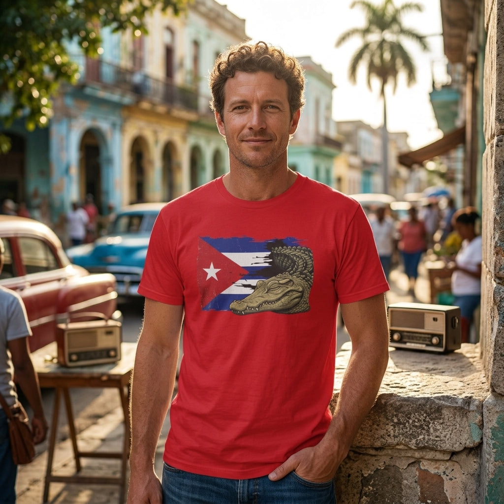 A man wearing a red graphic t-shirt with a Cuban flag and alligator design, standing in a vintage street setting with classic cars and colonial-style buildings.
