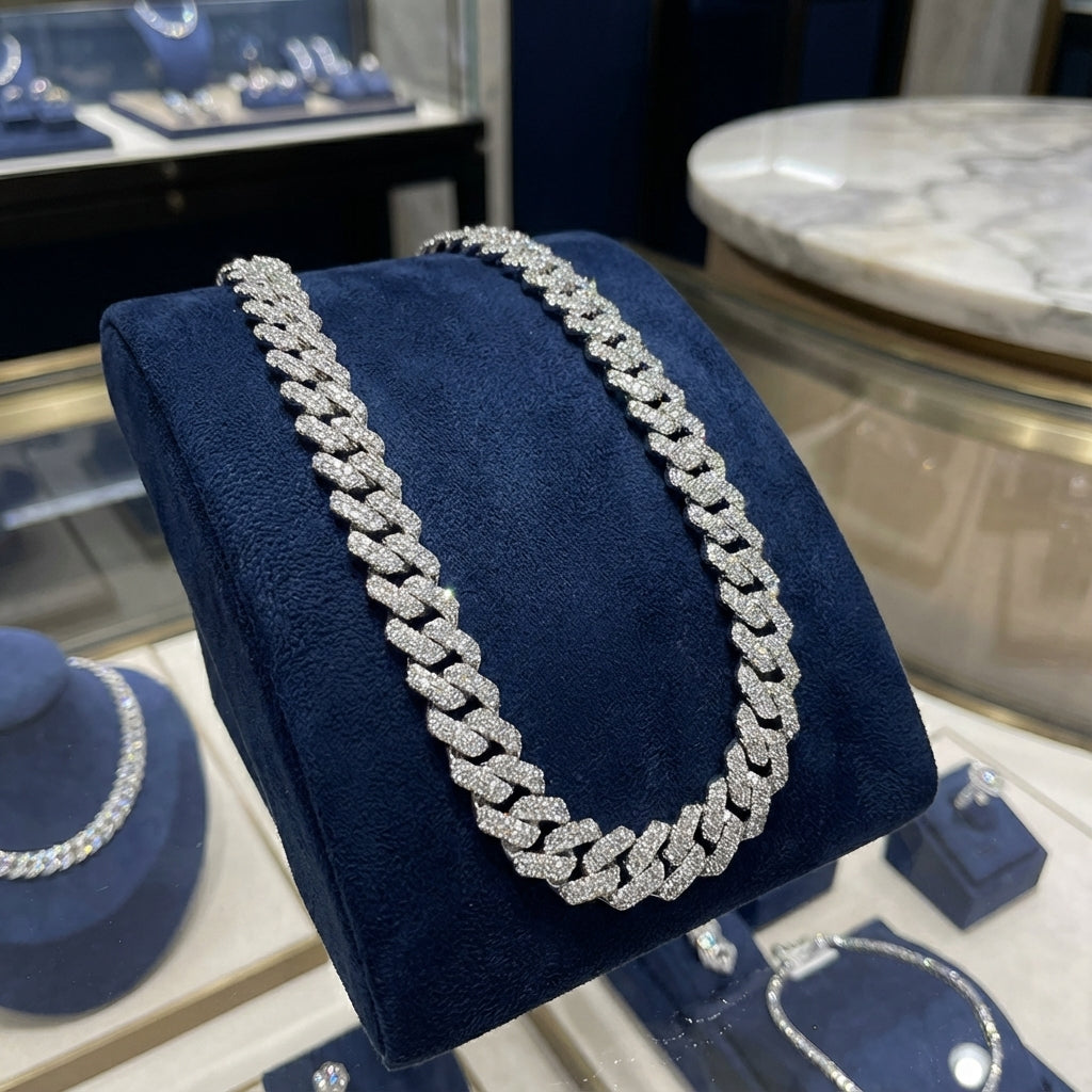 Silver chain necklace on a blue cushion in a jewelry store setting