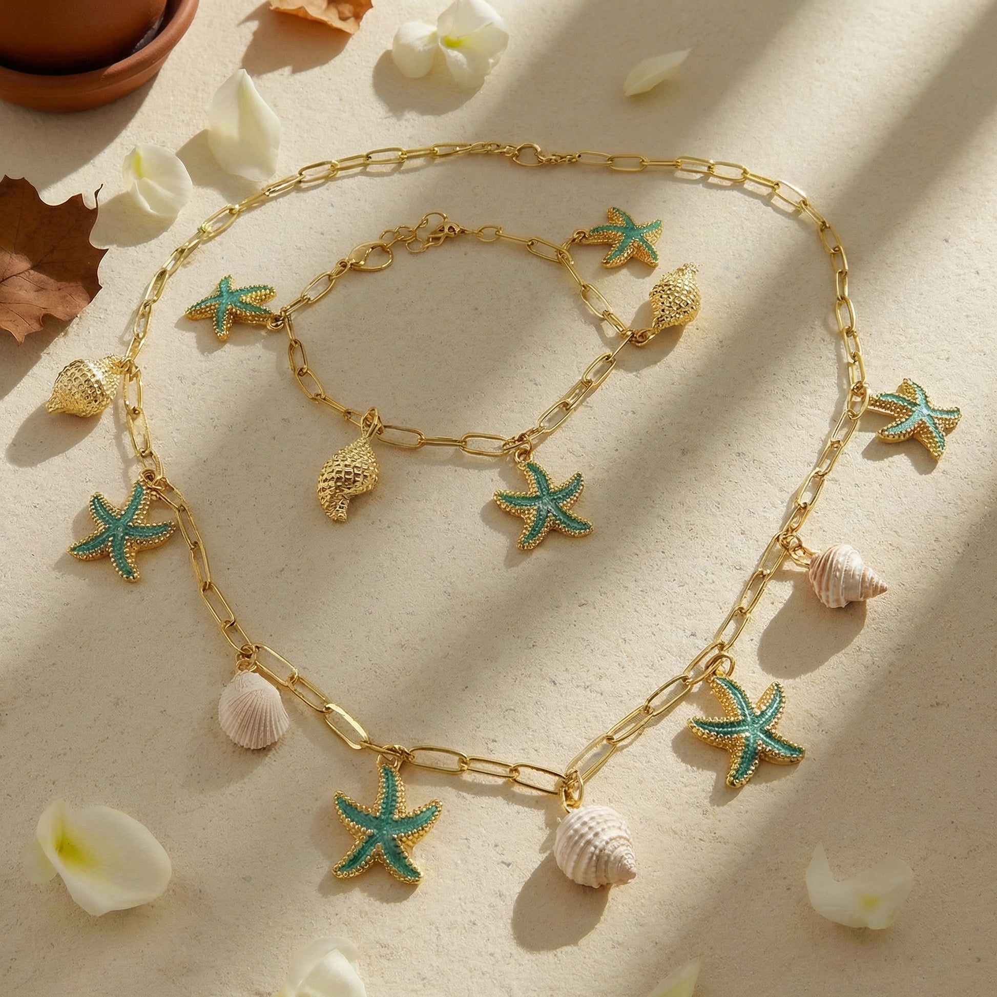 Gold necklace with starfish and shell charms on a light background
