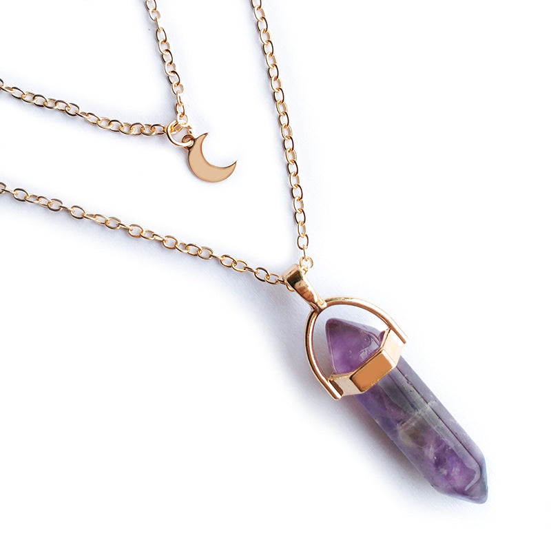 Amethyst crystal necklace with gold chain on a white background