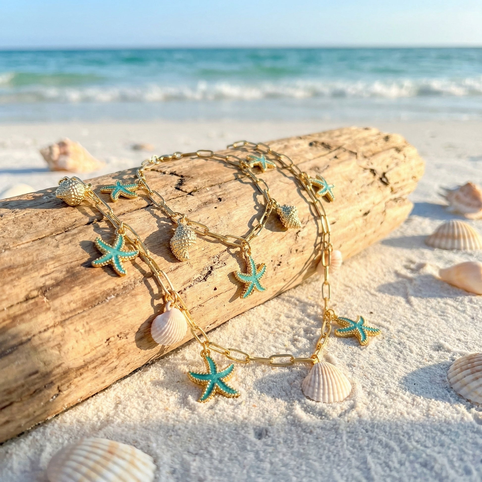 Gold anklets with starfish and shell charms on a beach setting