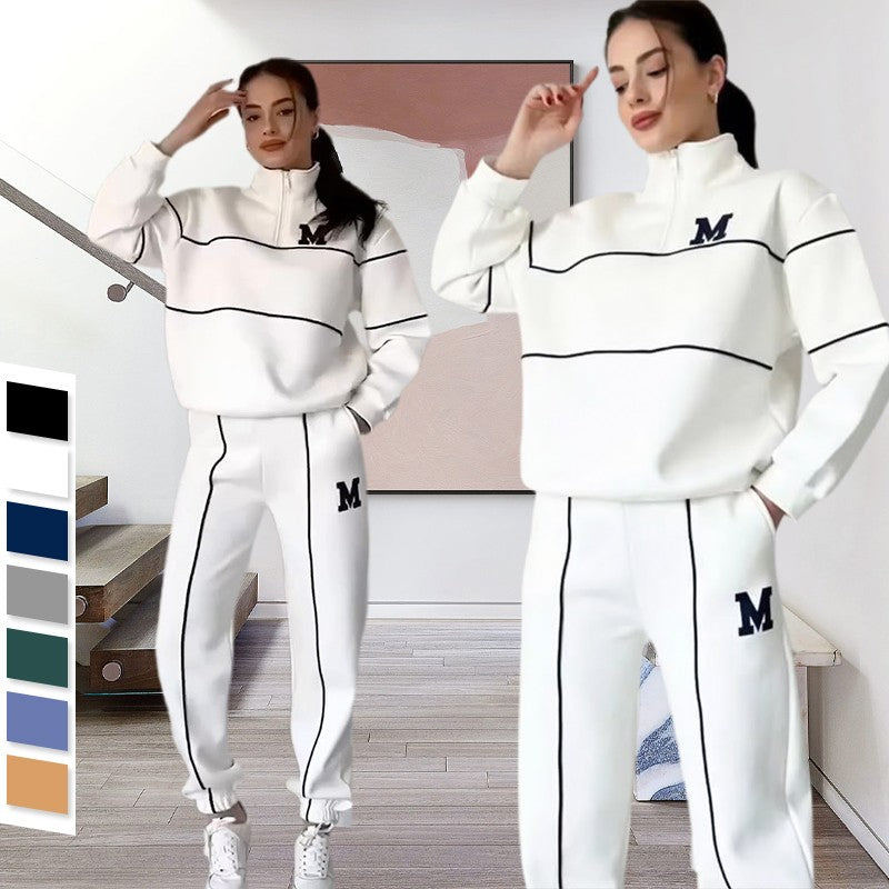 Woman wearing a white tracksuit with black accents and 'M' logos, standing in a room.