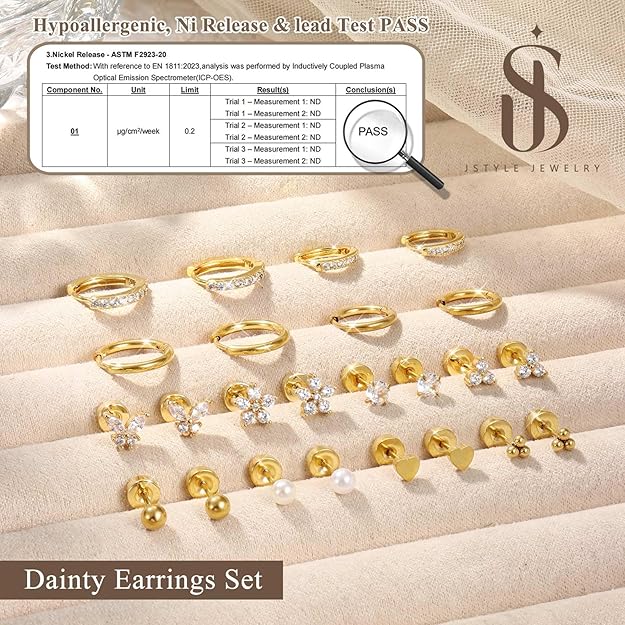 Set of gold earrings on a beige surface with a test pass certificate displayed.