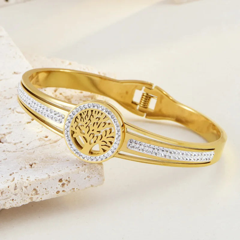 Gold bracelet with tree of life design on a light background