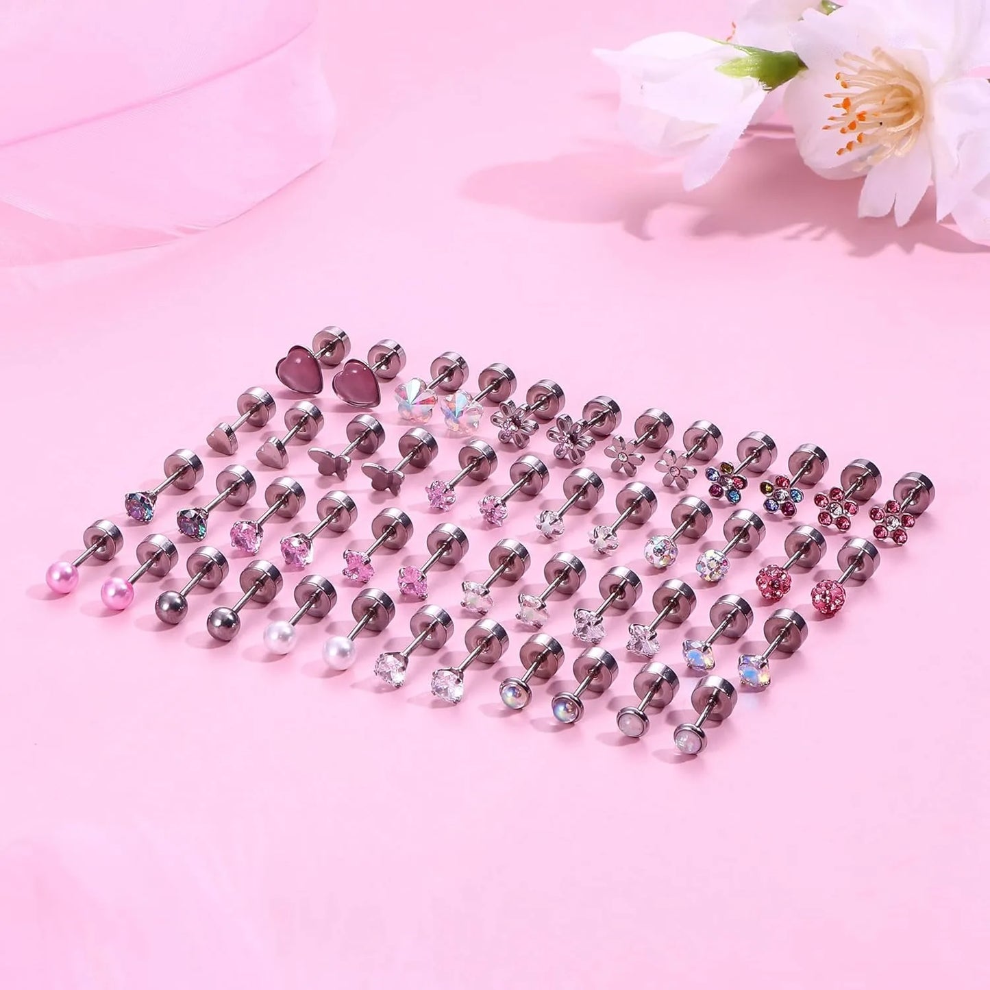 Assorted earrings on a pink background with flowers