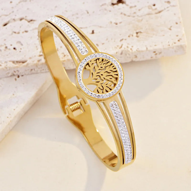 Gold bracelet with tree of life design on a light background