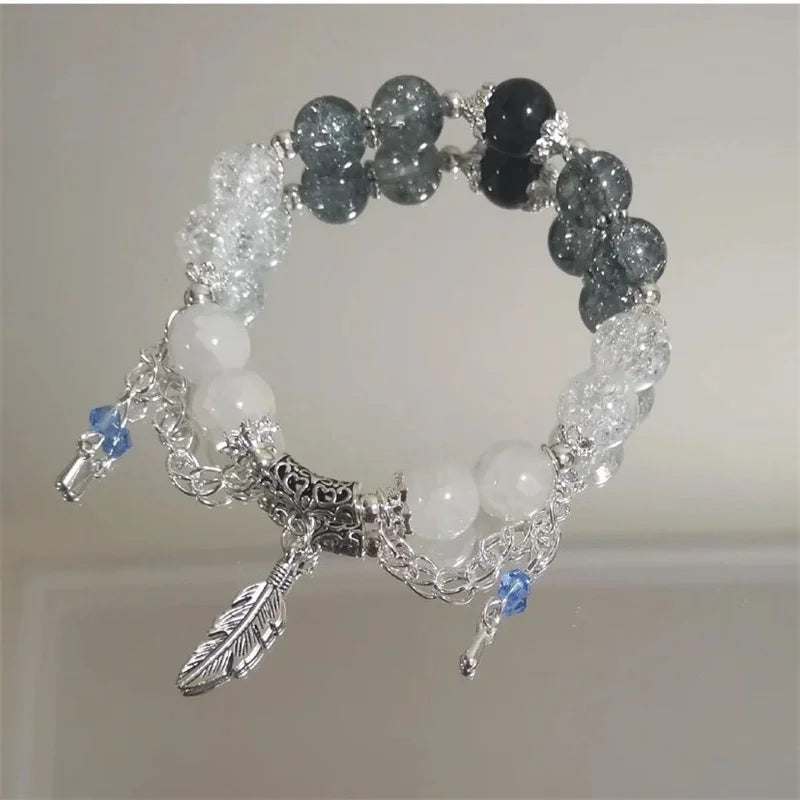 Beaded bracelet with silver charms on a neutral background