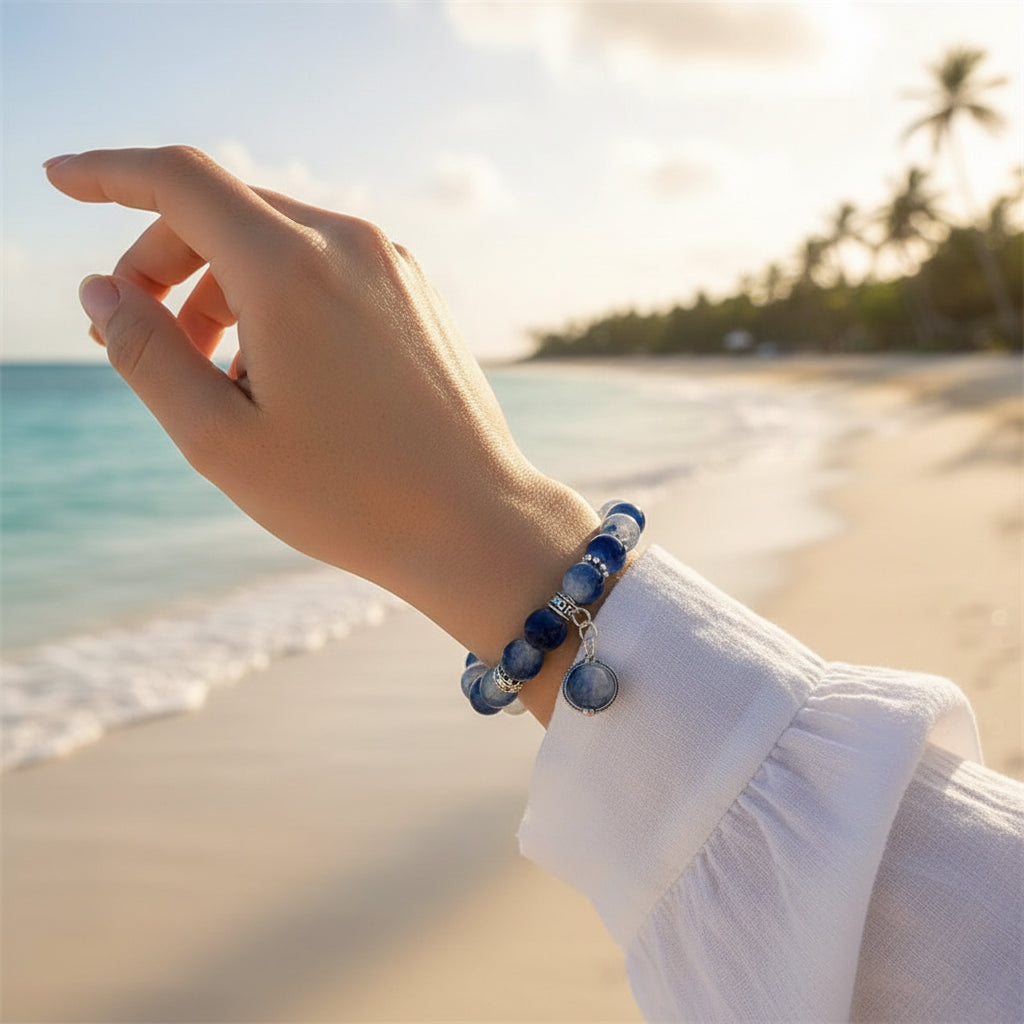 Blue beaded bracelet with a clear charm on a white fabric background
