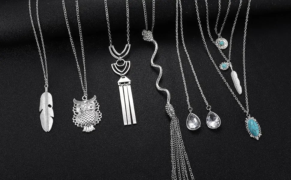 Collection of silver necklaces with various pendants on a black background
