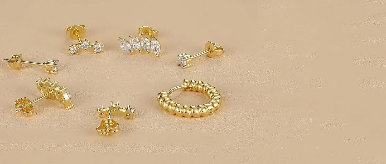 Set of gold earrings on a beige background