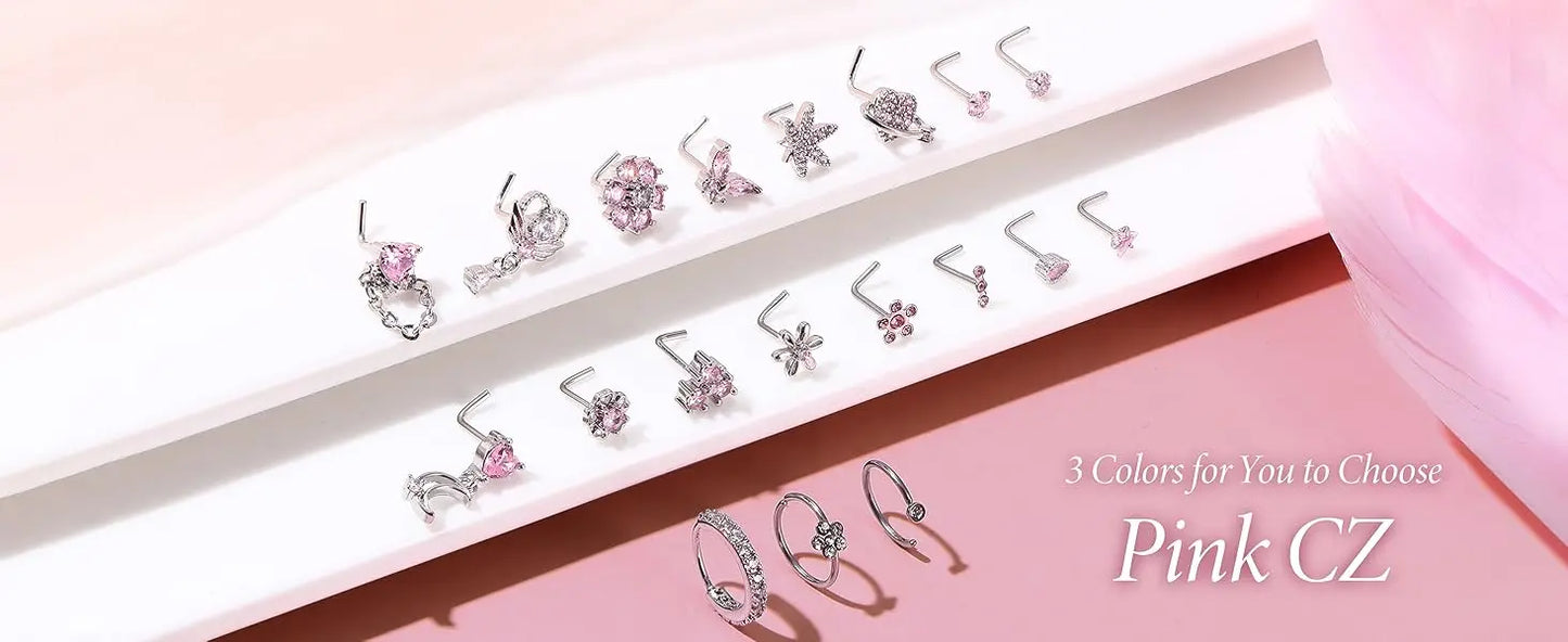 Set of earrings and rings with pink CZ stones on a pink background