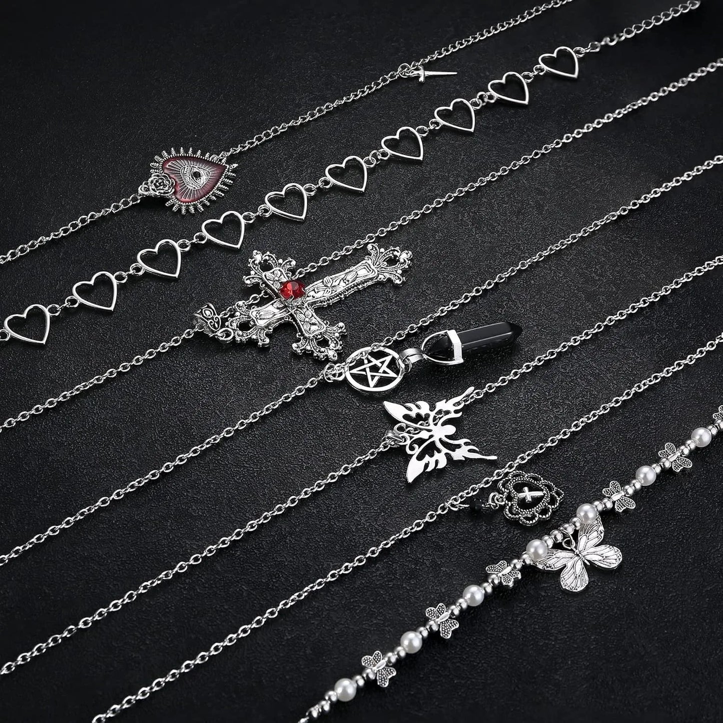 Silver necklaces with various charms on a black background