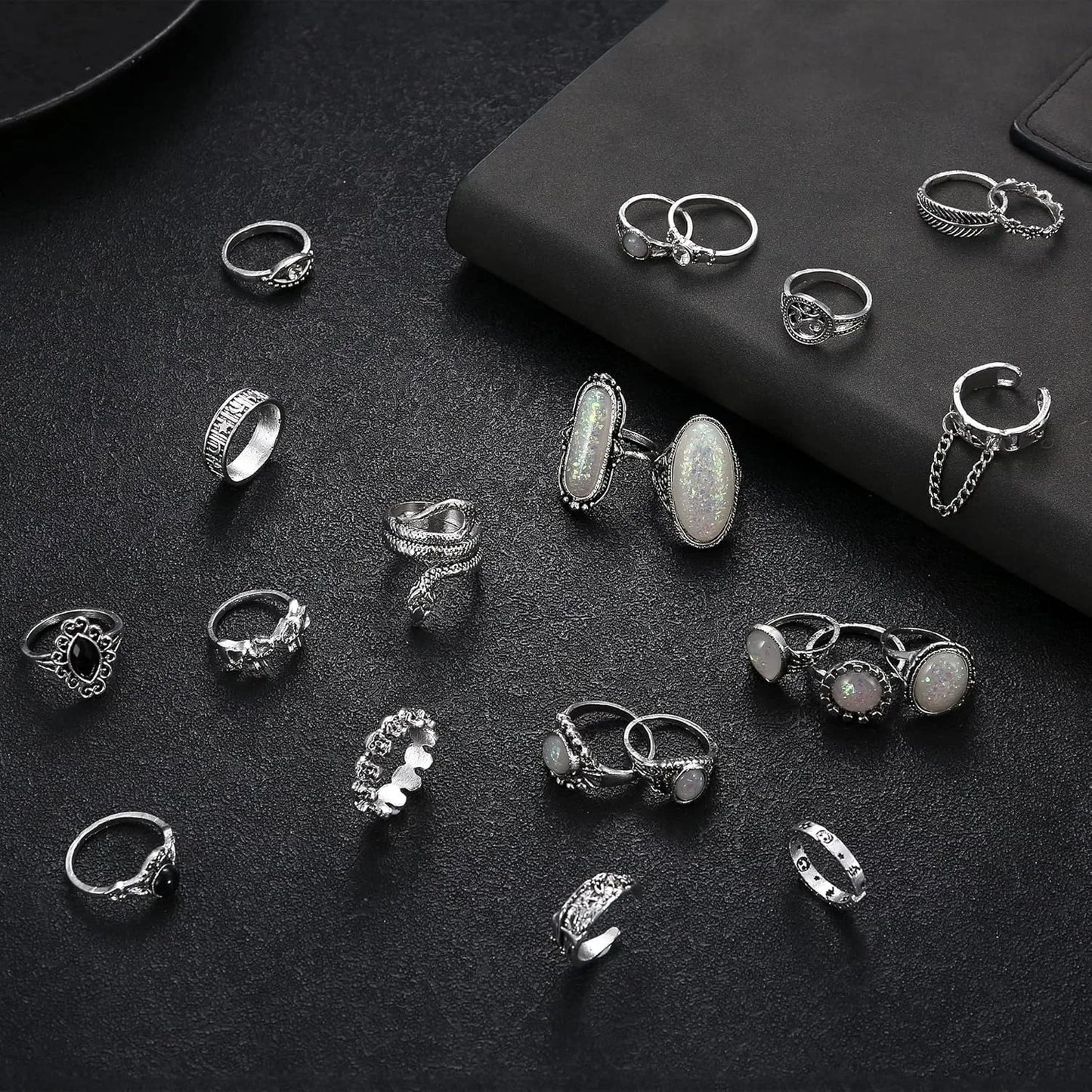 Collection of various silver rings on a dark surface