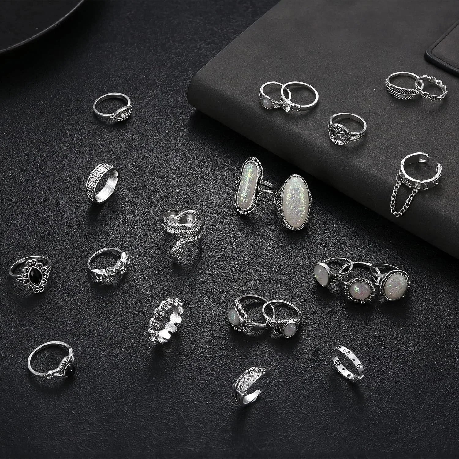 Collection of various silver rings on a dark surface