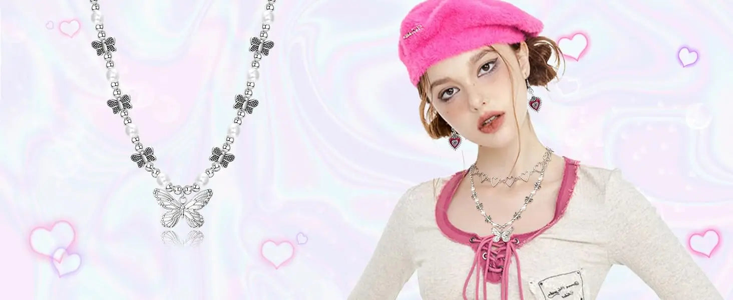 Woman wearing a pink hat and white top with butterfly necklace on a light pink background