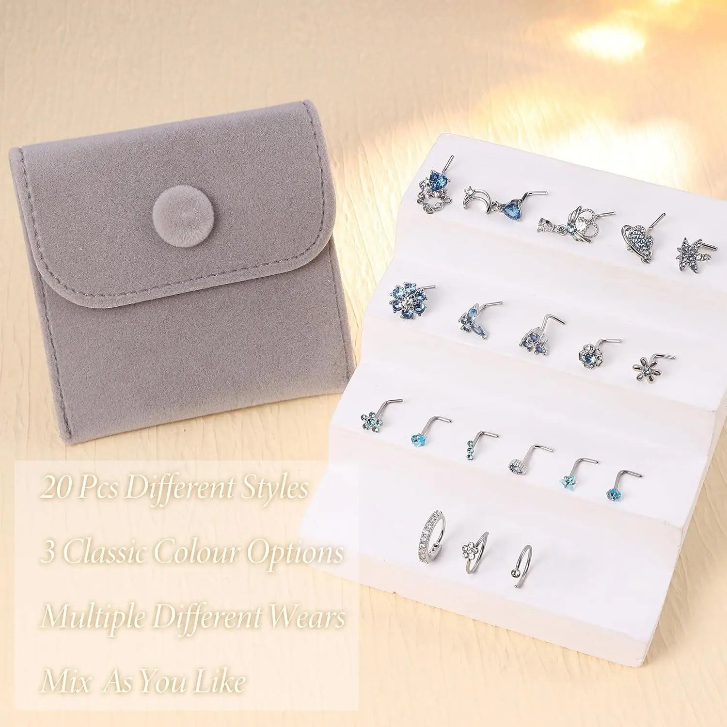 Set of 20 different styles earrings on a white card with a gray jewelry pouch on a beige background.